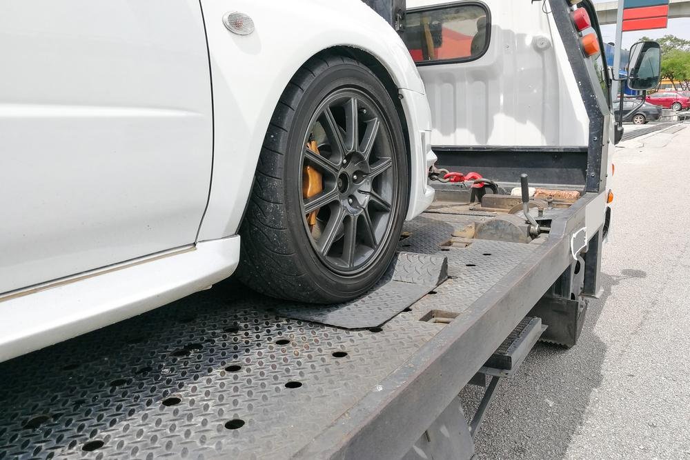 White car loaded on a flatbed tow truck